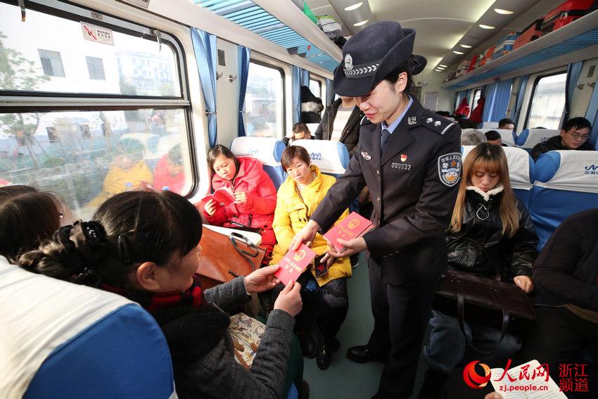 12月4日乘警在车厢内向旅客免费发放《中华人民共和国宪法》。韦士钊 摄