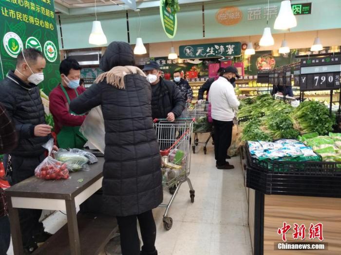 资料图：市民戴口罩选购蔬菜。/p中新社记者 丁喆 摄